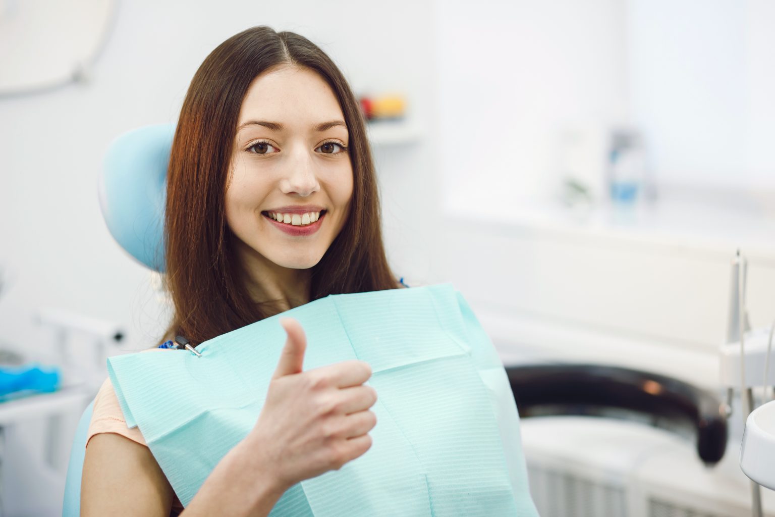 Smiling dentist holding a dental mirror